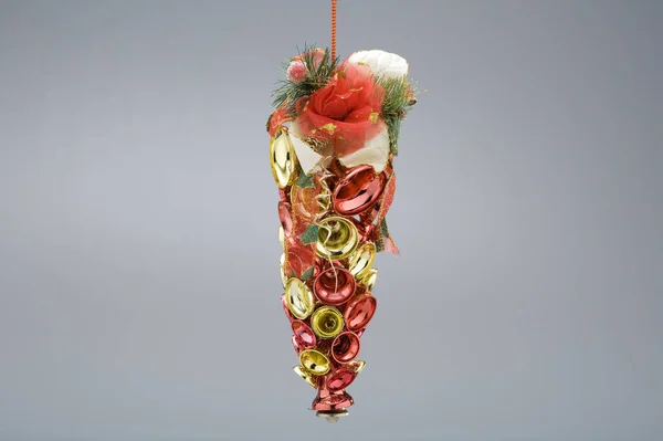 Kırmızı ve altın çanlardan yapılmış Noel ağacı süsü, gri renkte izole edilmiş.