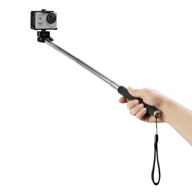 Beyaz arka planda gümüş renkli aksiyon kamerası olan selfie çubuğu tutan kadın. 