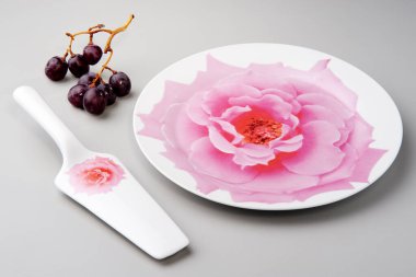 Yuvarlak pasta tabağı ve kek küreğiyle, gül desenli, izole