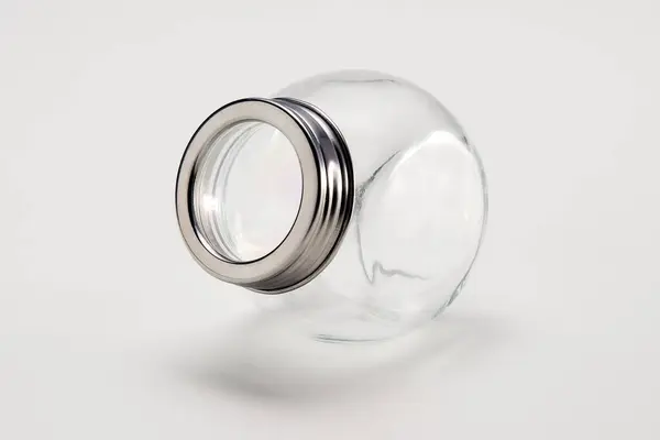 Gümüş kapaklı boş cam kavanoz, beyaza izole edilmiş.