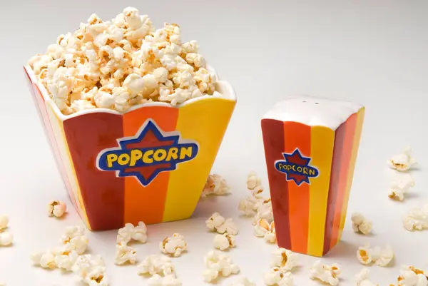 Turuncu ve sarı seramik yay, patlamış mısır ve tuz dağıtıcı ile izole edilmiş.