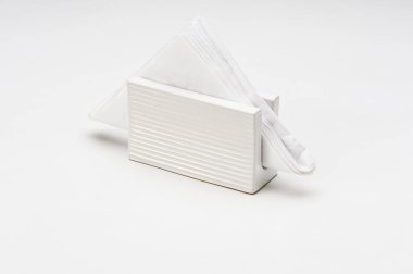 Beyaz seramik peçete tutacağı, içinde peçete, beyaz üzerine izole edilmiş.