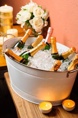 Soğuk şampanya şişeleri, beyaz bir buz kovasının içinde, özel bir Noel gecesinde..