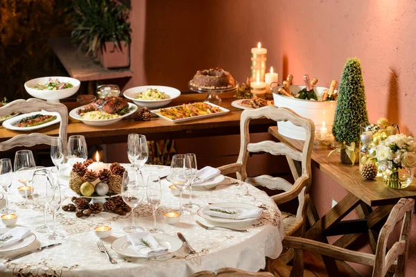 Güzel bir Noel yemeği masası, arka planda büfe, tatlı, şampanya ve tipik dekorasyon..