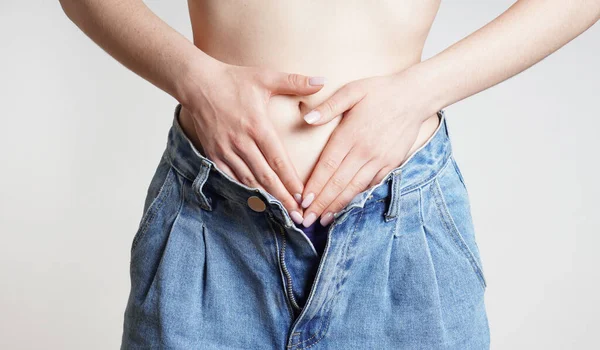 腹部や期間の痛みを伴うお腹を持つジーンズの女性 — ストック写真