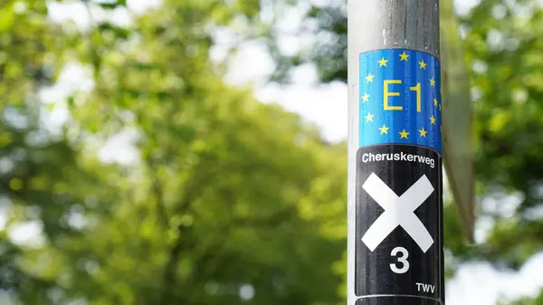 stock image DETMOLD, NORTH RHINE-WESTPHALIA, GERMANY - JULY 25, 2024: Signpost for E1 European long-distance path and X3 Cheruskerweg walking trail