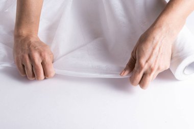 Woman hands working with  Covering Roll for Medical Bed