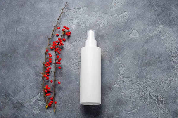 Beyaz plastik şişe ve koyu taştan arka planda au var.