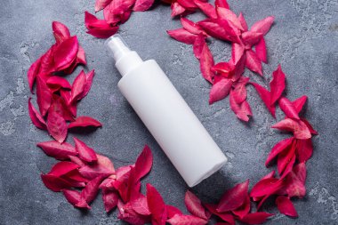 Beyaz plastik şişe ve koyu taştan arka planda au var.