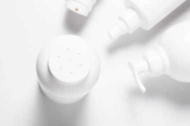 Delinmiş bardaklı beyaz plastik talk şişesi.