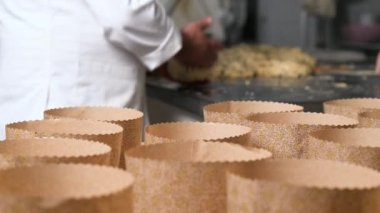 İtalyan zanaatkar fırıncı panettone noel pastası hamurunu kalıplara koyuyor. Yüksek kalite 4k görüntü