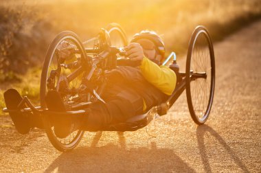 Özürlü Genç Bir Sporcunun El Bisikleti Sürüşü Sahnesi. Sunset 'te Adaptive Egzersiz. Yüksek kaliteli fotoğrafçılık.