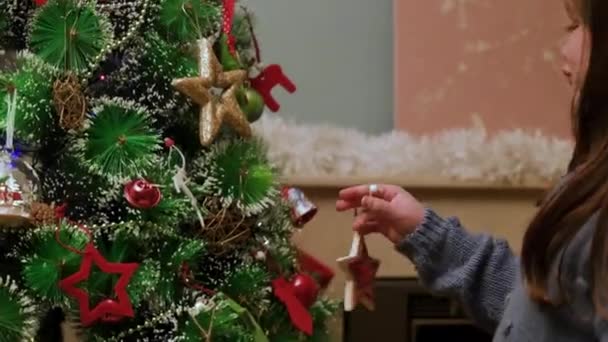 小女孩用装饰品装饰圣诞树 高质量的4K镜头 — 图库视频影像