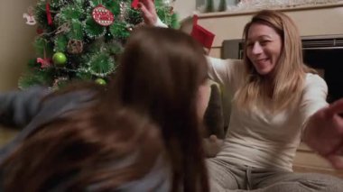 Genç anne ve kızı Noel hediyesi kutusunu Xmas Ağacı 'nın önünde açıyor. Mutlu anne ve küçük kız Sihirli Gece 'de. Aileniz mutlu noeller ve yeni yıl tatili konsepti. Yüksek kalite 4k görüntü