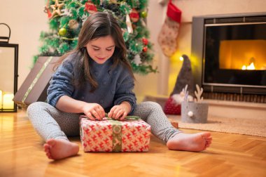 Noel hediyesini açan tatlı kız. Yüksek kaliteli fotoğrafçılık.