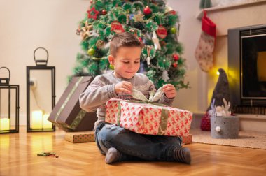 Çocuk yılbaşı hediyesini açıyor. Yüksek kaliteli fotoğrafçılık.