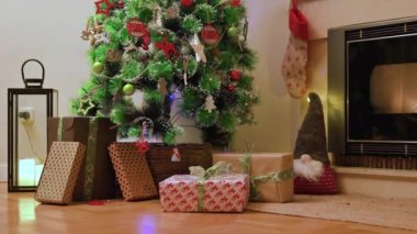 Kardeşler güzel dekore edilmiş Noel ağacıyla oturma odasına koşuyorlar, büyük kutulara sarılmış hediyeleri açmak için sabırsızlanıyorlar. Yüksek kalite 4k görüntü