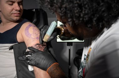 Dövme sürecini kapat. Usta profesyonel dövme makinesiyle hatlar çiziyor. Yüksek kaliteli fotoğrafçılık