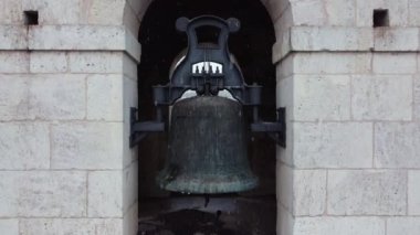 Close up of a bell on bell tower on top of an ancient church on a snow day in Spain. High quality 4k footage