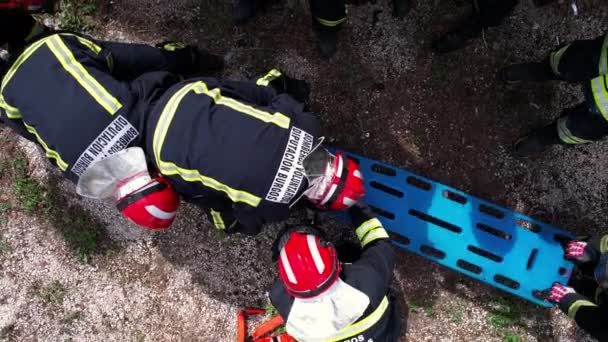 負傷者を輸送するためにストレッチャーと車の事故後の負傷者の救助中に行動中の消防士 高品質4K映像 — ストック動画