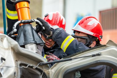 İtfaiyeciler kurtarma operasyonu eğitiminde hidrolik aletler kullanıyorlar. Kurtarma ekipleri kazadan sonra yolcunun kapısını açtılar. Yüksek kaliteli fotoğrafçılık.