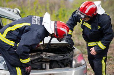 Araba kazası, trafik kazası, trafik kazası. İtfaiyeciler, Yaralı Kurbanlar. İtfaiyeciler yolculara ilk yardım sağlar. Yüksek kaliteli fotoğrafçılık.