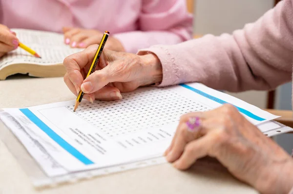 Ruce Seniorů Kteří Společně Řeší Test Hledání Slov Pečovatelském Domě — Stock fotografie