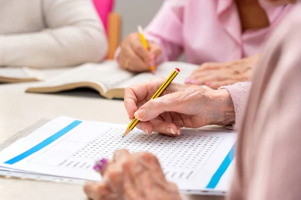 stock image Hands of senior people solving together a word search quiz at nursing home. High quality photo