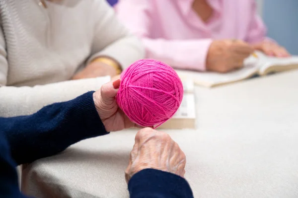 老人ホームで手織りの糸を巻きながら老婦人の手を閉じる 高品質の写真 — ストック写真