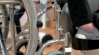 Tanınmayan yaşlı bir kadın hastanede tekerlekli sandalyeden pedal egzersizi yapıyor. Yüksek kalite fotoğraf.