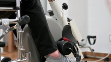 Tanınmayan yaşlı bir kadın hastanede tekerlekli sandalyeden pedal egzersizi yapıyor. Yüksek kalite fotoğraf.