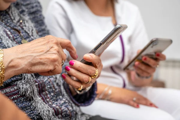 stock image Nurse teaching elder woman how to use mobile phone, senior grandmother learning to use smartphone at nursing home. Modern technology for elderly. High quality photo.
