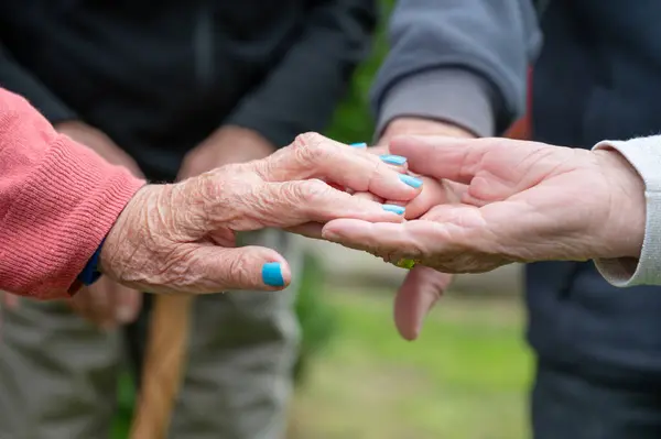 Closeup of elderly couple holding hands. Husband and wife holding hands and comforting each other. Love and care concept. High quality photo