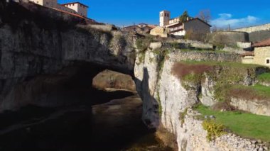 Puentedey 'in havadan görünüşü, nehrin üzerinde doğal bir köprüsü olan pitoresk bir köy. Burgos, İspanya. Yüksek kalite 4k görüntü