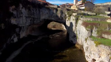 Puentedey 'in havadan görünüşü, nehrin üzerinde doğal bir köprüsü olan pitoresk bir köy. Burgos, İspanya. Yüksek kalite 4k görüntü
