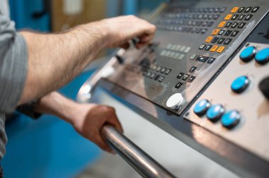 Fabrikadaki CNC kontrol panosundaki düğmelere basan işçiler. Yüksek kaliteli fotoğrafçılık.