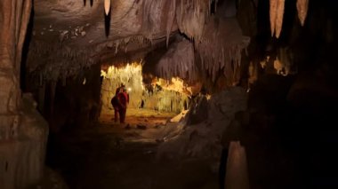Mağaranın içinde, farlarla aydınlatılmış gizemli yeraltı sisteminin derinliklerini araştıran bir grup mağara bilimci. Yüksek kalite 4k görüntü