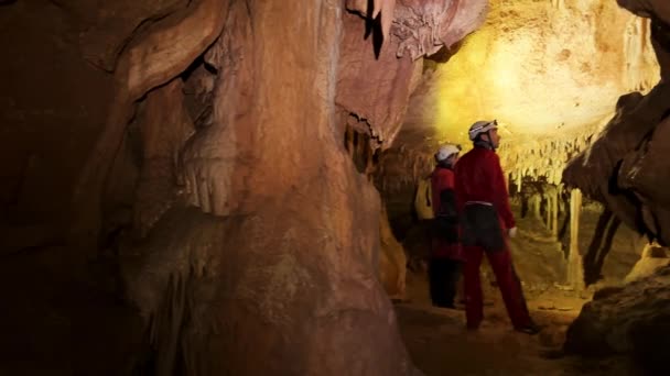 Группа Спелеологов Внутри Пещеры Освещенной Фарами Исследует Глубины Таинственной Подземной — стоковое видео