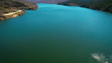 Manzaralı bir dağ gölünün havadan görünüşü ve hidroelektrik enerji üretimi için bir baraj. Yüksek kalite 4k görüntü