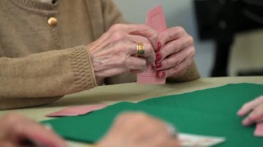 Aktif emeklilik, huzurevinde kağıt oynarken eğlenen bir grup yaşlı kadın. Yüksek kalite 4k görüntü