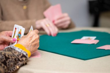 Aktif emeklilik, huzurevinde kağıt oynarken eğlenen bir grup yaşlı kadın. Yüksek kaliteli fotoğrafçılık.