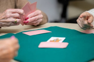 Aktif emeklilik, huzurevinde kağıt oynarken eğlenen bir grup yaşlı kadın. Yüksek kaliteli fotoğrafçılık.