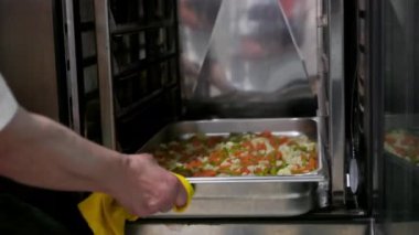 Ticari mutfakta sebze güveci hazırlayan şefe yakın çekim. Yüksek kalite 4k görüntü