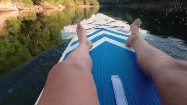 Gölde kayak yaparken. Güzel bir manzarada kano süren bir adam portresi. Yaz konsepti sırasında su sporları. Güzel, sakin, rahatlatıcı, sıcak manzaralı bir yer. Yüksek kalite 4k görüntü