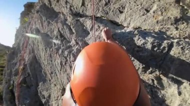 Kaya tırmanışı POV 'u. Bir kaya tırmanıcısının yukarı doğru hareket edişinin aşırı görüntüsü. Yüksek kalite 4k görüntü