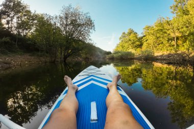 Gölde kayak yaparken. Güzel bir manzarada kano süren bir adam portresi. Yaz konsepti sırasında su sporları. Güzel, sakin, rahatlatıcı, sıcak manzaralı bir yer. Yüksek kaliteli fotoğrafçılık