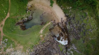 İspanya 'nın Asturias şehrinde kayalık bir kıyı şeridindeki doğal bir kemerin havadan görünüşü. Yüksek kalite 4k görüntü
