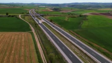 Tarlaların üzerinde uçarken bir karayolunda 4K 'lık yüksek hız trafiği. Yüksek kalite 4k görüntü