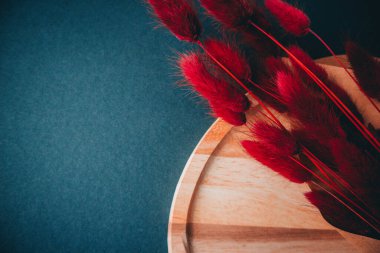 Mavi arka planda ahşap tahta ve kırmızı çiçekler. Uzayı kopyala Temiz arkaplan