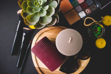 Mumlar, tahta tahta tahta, gölge, kaktüs, makyaj fırçası ve siyah arka planda güneş gözlüğü. Boşluğu kopyala